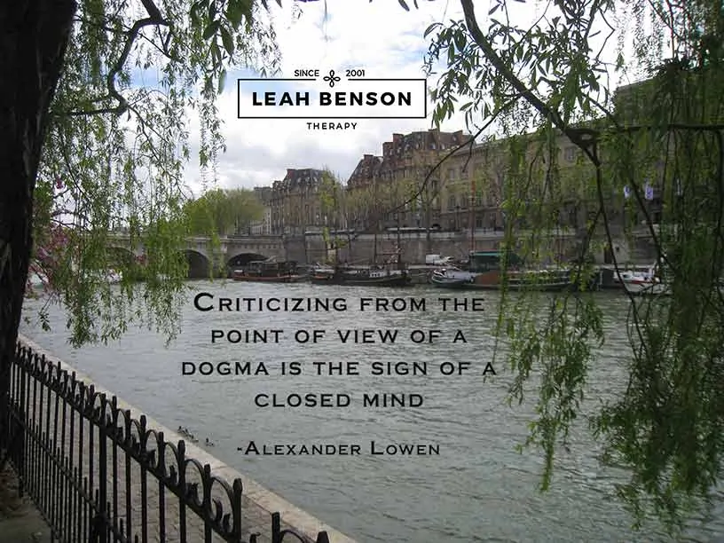 Photo of Seine River in Paris with boats and a bridge. Quote by Alexander Lowen, "Criticizing from the point of view of a dogma is the sign of a closed mind"