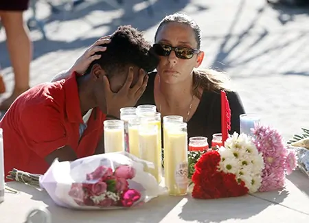 Photo of mourning children with flowers and candles