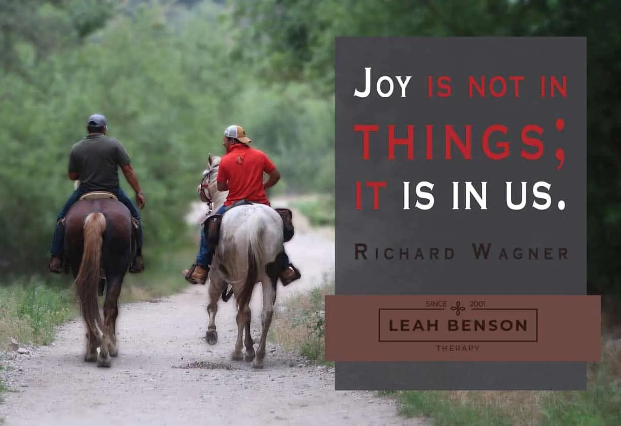 Photo of 2 horsemen on a trail with text, "Joy isn't in Things, It's In Us"