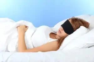 woman in bed with eyeshades.